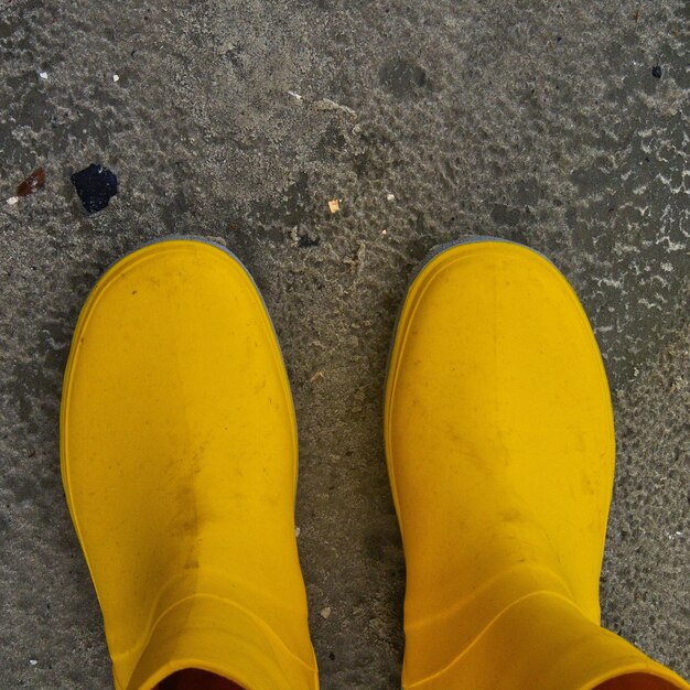 Low section of person standing on yellow road