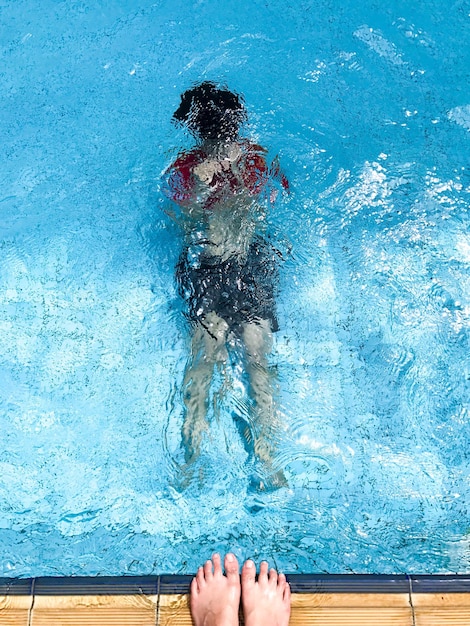 Photo low section of person swimming by pool