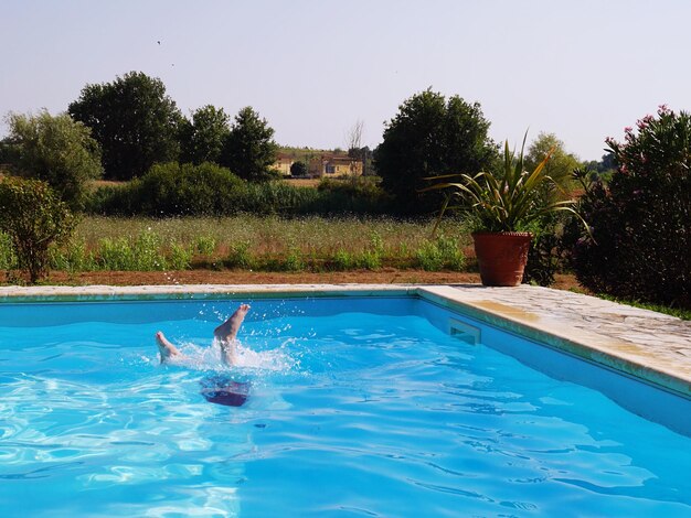 Low section of person swimming in pool