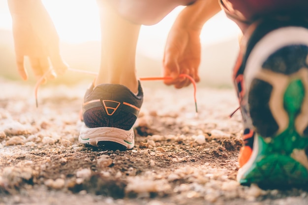 Foto sezione inferiore di una persona che lega i lacci delle scarpe sul campo