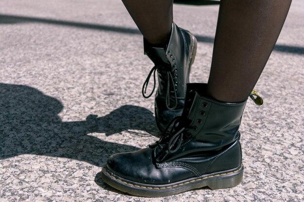 Foto sezione bassa di una persona che indossa scarpe per strada