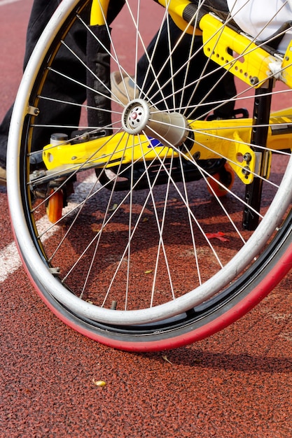 Foto sezione inferiore della persona in sedia a rotelle in pista sportiva
