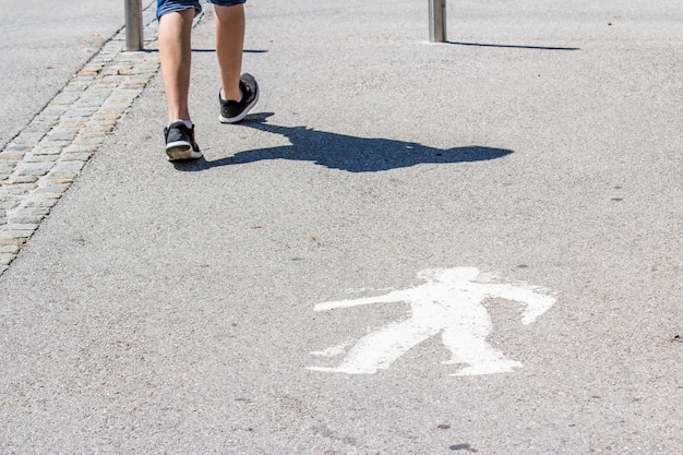 Foto sezione bassa di una persona con un ombrello sulla strada