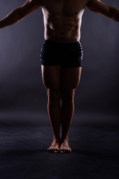 Low section of shirtless man standing in gym