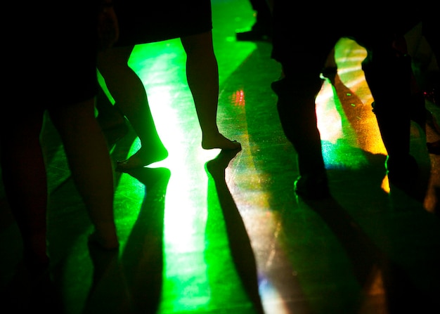 Photo low section of silhouette people dancing on floor in nightclub