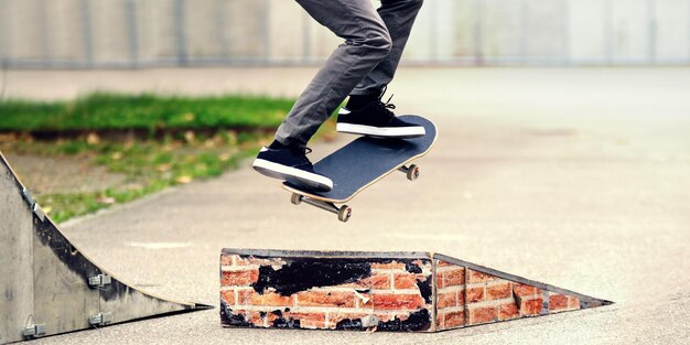 Photo low section of skateboarder jumping