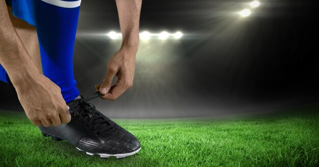 Photo low section of soccer player typing shoelace