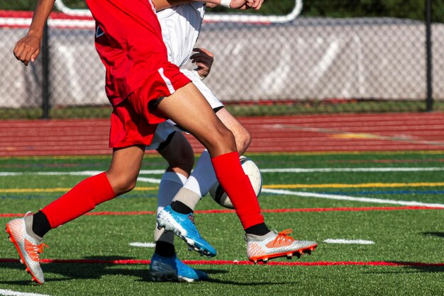 Photo low section of soccer players playing at field