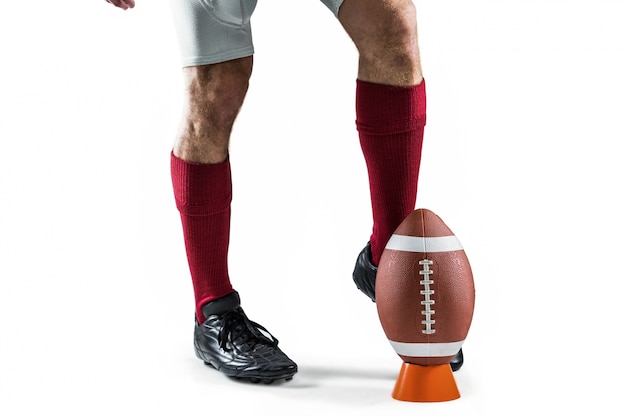 Low section of sportsman kicking ball