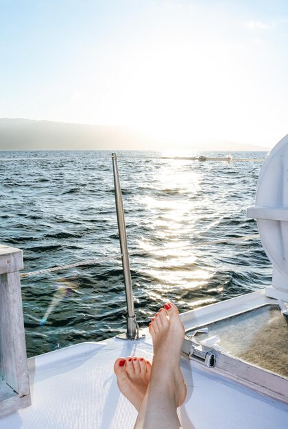 Foto sezione bassa di una donna in barca sul mare contro il cielo