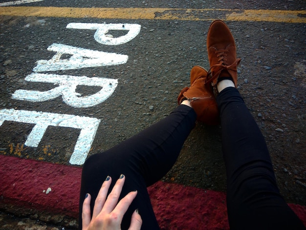 Photo low section of woman by text on road