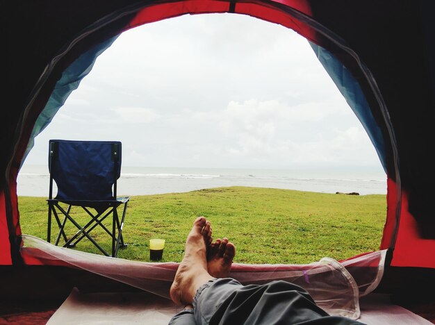 Low section of woman in camp against sea