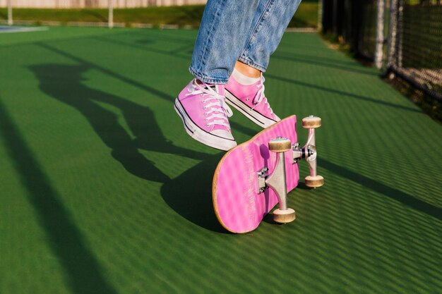 Foto sezione bassa di una donna che fa un trucco con lo skateboard