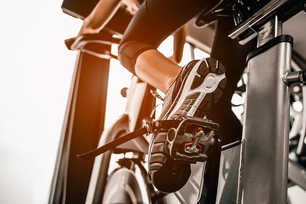 Low section of woman on exercise bike at gym