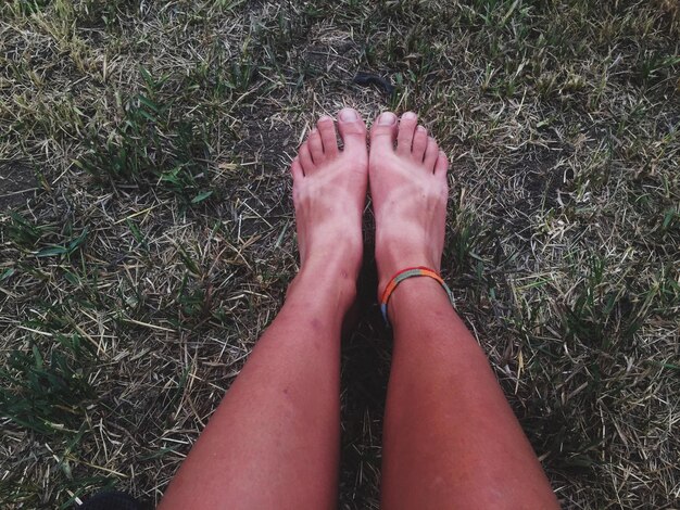Low section of woman feet on field
