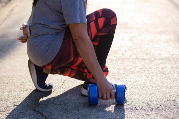 Photo low section of woman holding dumbbell on road