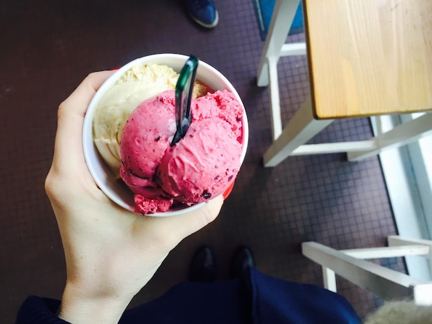 low section of woman holding ice cream at home