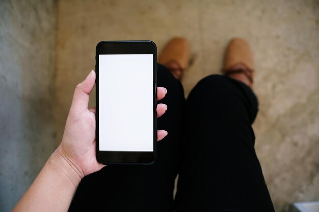 Low section of woman holding smart phone