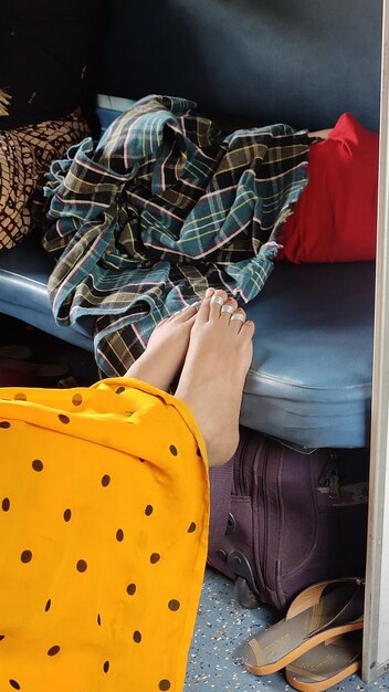 Low section of woman holding yellow umbrella