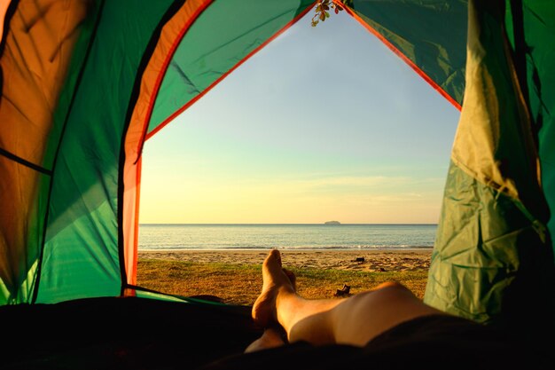 Low section of woman lying on beach against sky