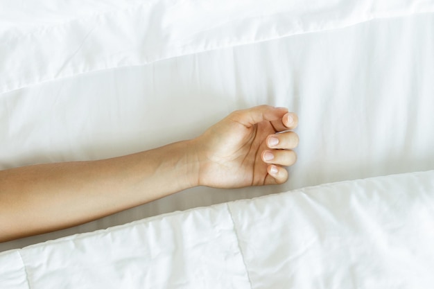 Low section of woman lying on bed at home