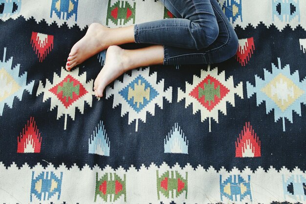 Photo low section of woman lying on carpet