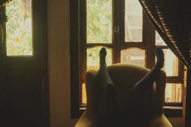 Photo low section of woman lying on chair at home