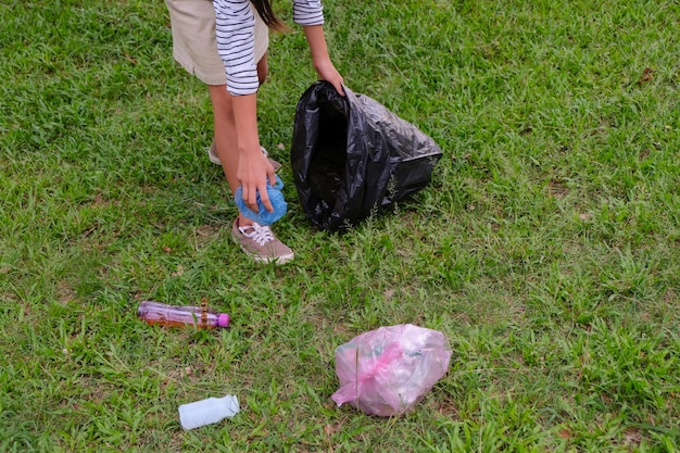 写真 野原でゴミを拾う女性