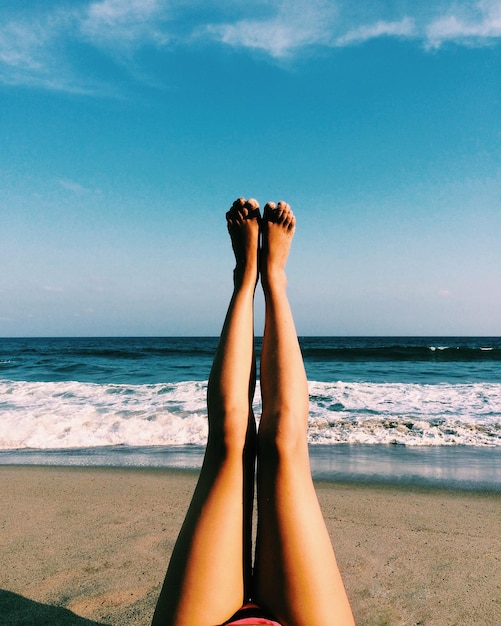 Foto sezione bassa di una donna che si rilassa sulla spiaggia