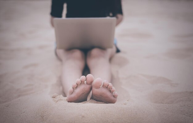 Photo low section of woman relaxing on sand at beach