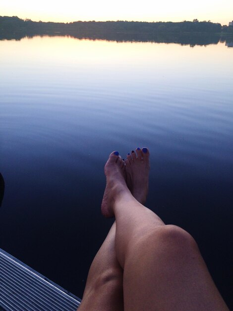 Photo low section of woman relaxing over sea against sky