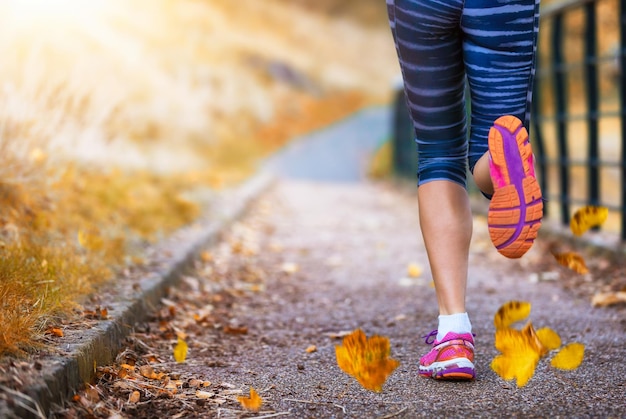 Photo low section of woman running on footpath during autumn