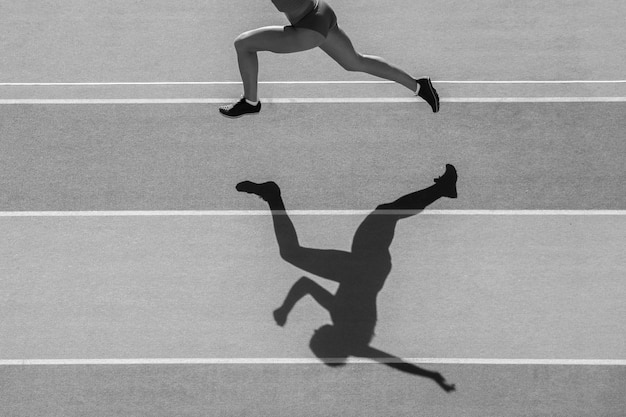 Low section of woman running on track