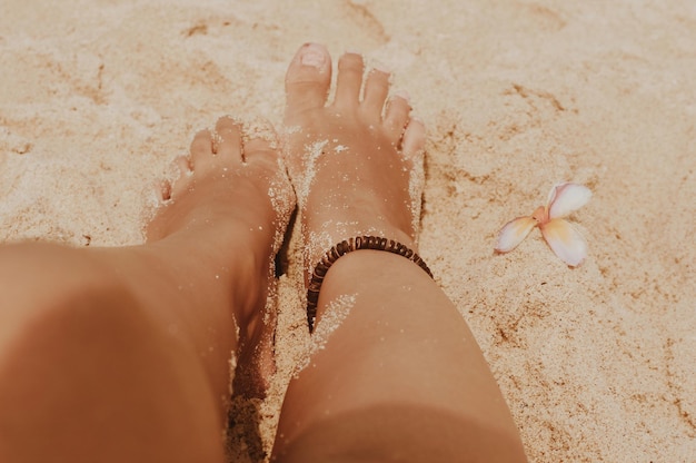 Foto sezione bassa di una donna sulla sabbia sulla spiaggia