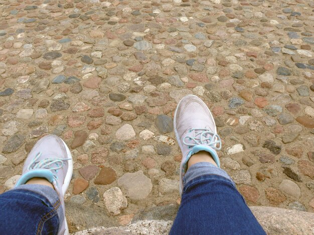 Foto sezione bassa di una donna seduta su una roccia