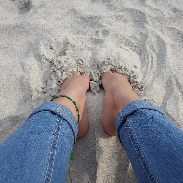 Photo low section of woman sitting on sand