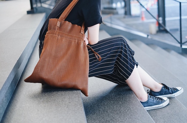 街の階段に座っている女性の下部