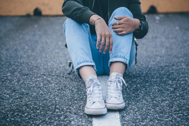 low section of woman sitting on street