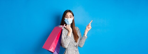 Low section of woman standing against blue background