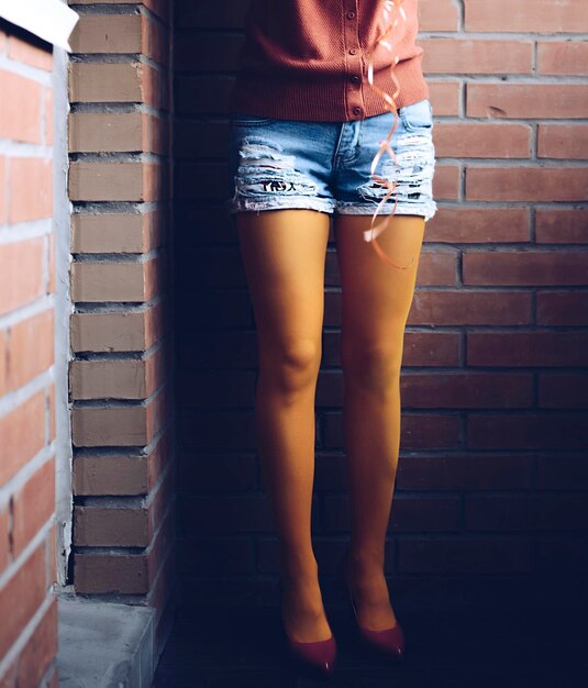 Photo low section of woman standing against wall