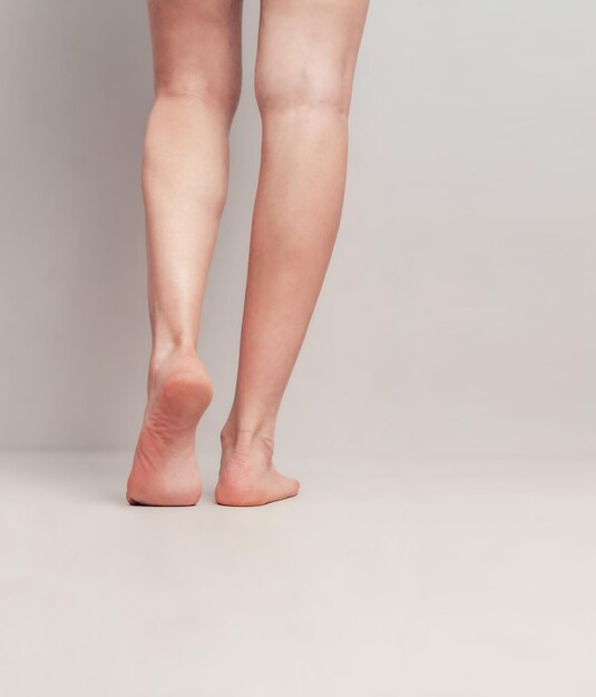 Low section of woman standing against white background