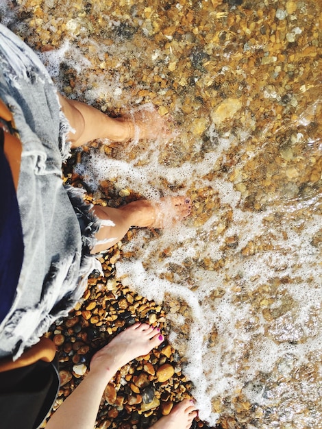 Foto sezione bassa di una donna in piedi sulla spiaggia