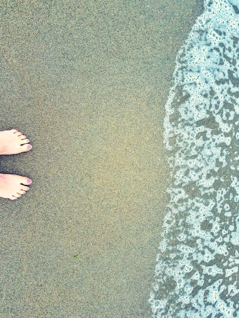 Foto sezione bassa di una donna in piedi sulla spiaggia