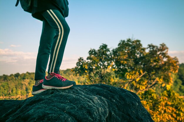 Foto sezione bassa di una donna in piedi sulla scogliera