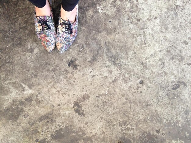 Low section of woman standing on concrete floor