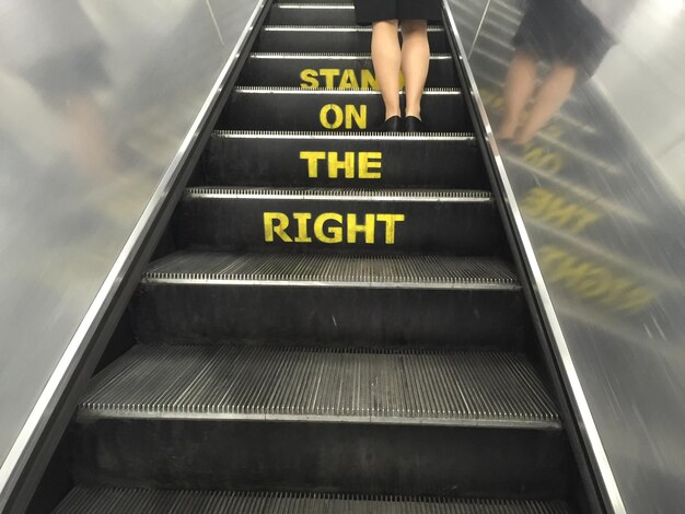 Photo low section of woman standing on escalator
