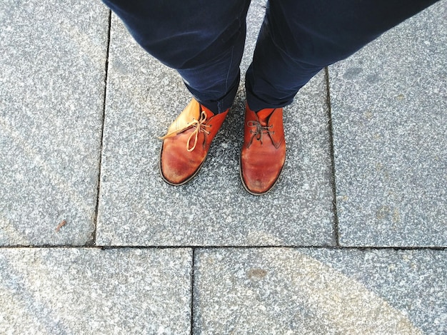 Low section of woman standing on footpath