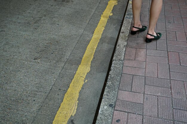 Foto sezione bassa di una donna in piedi sul marciapiede