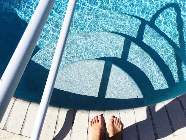 low section of woman standing poolside