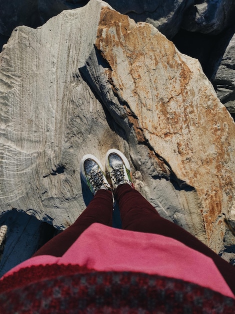 Foto sezione bassa di una donna in piedi su una roccia